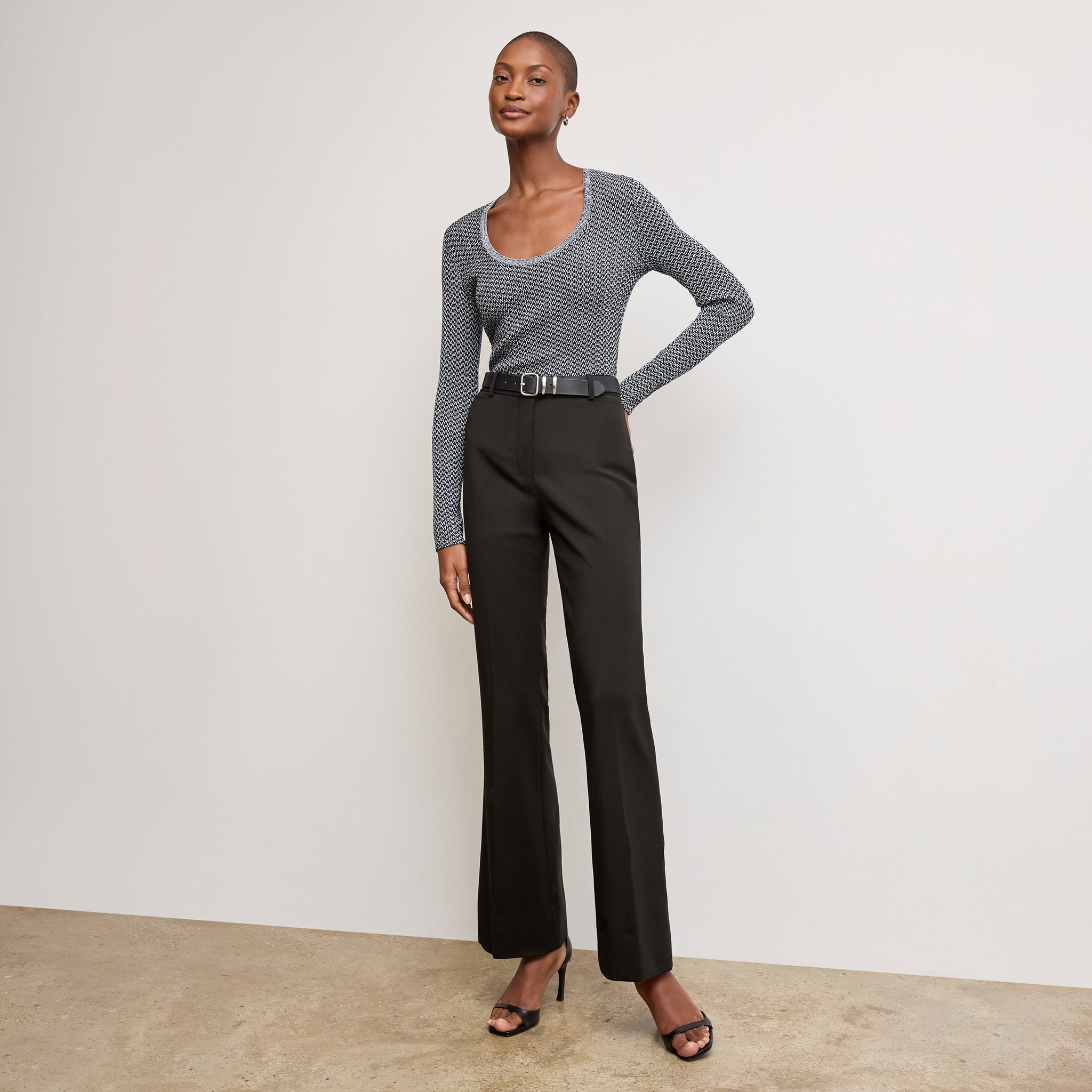 Front image of a woman sitting wearing the Horton pant in black 