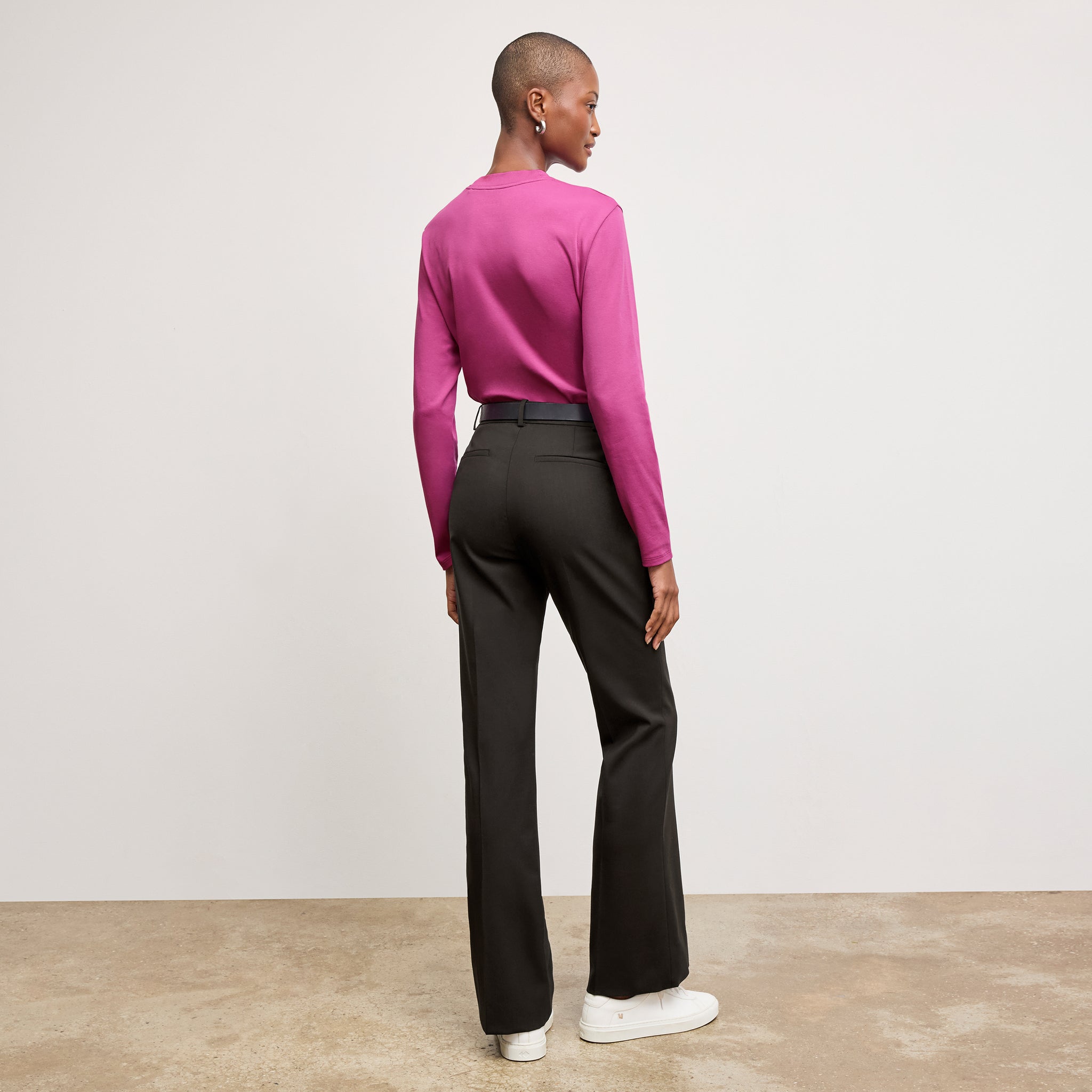 Front image of a woman sitting wearing the Horton pant in black