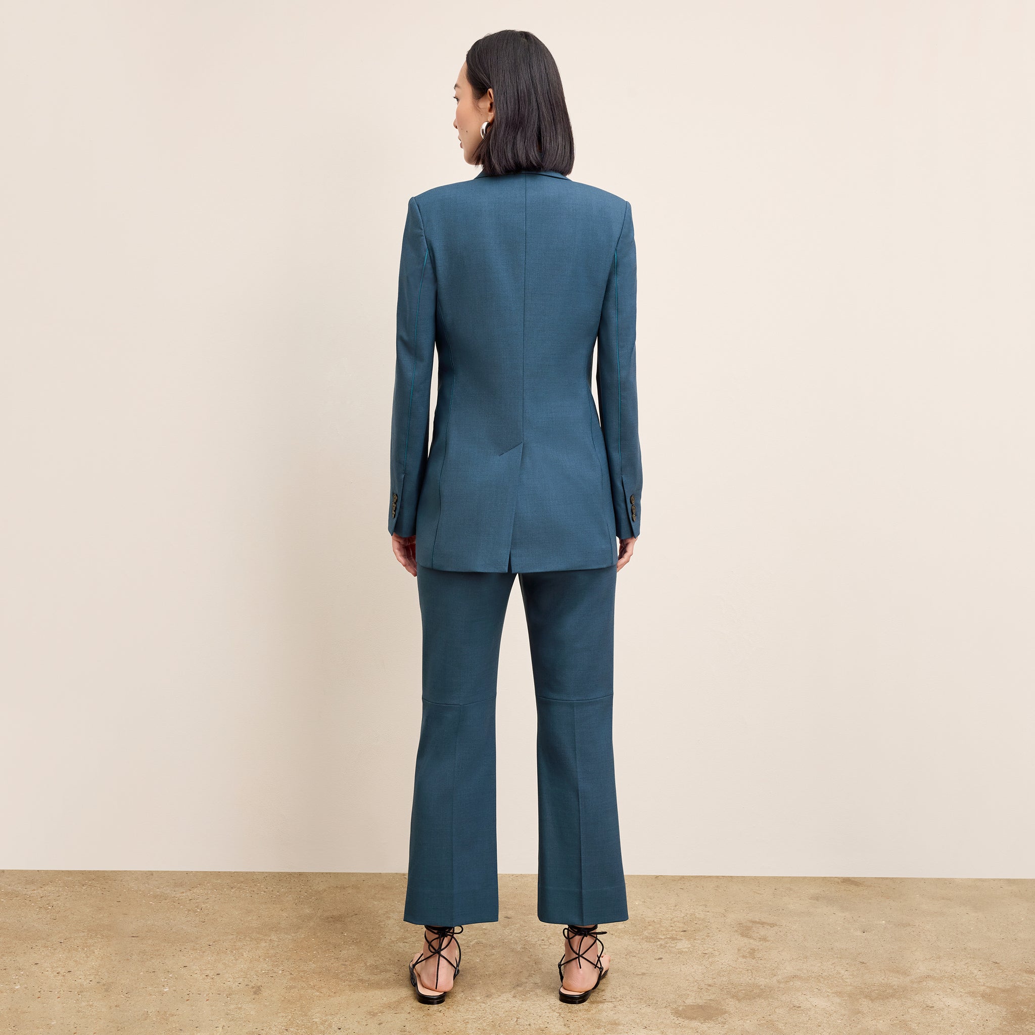back image of a woman wearing the rossi jacket in bluebell