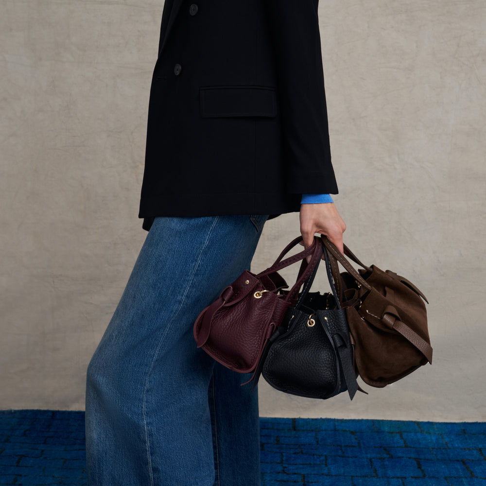 image of a woman holding 3 handbags