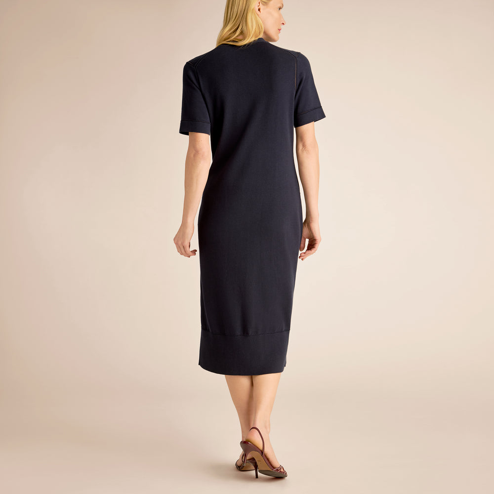 Woman wearing a black dress against a beige background