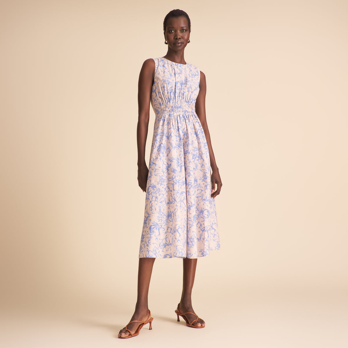 Woman wearing a floral dress on a beige background