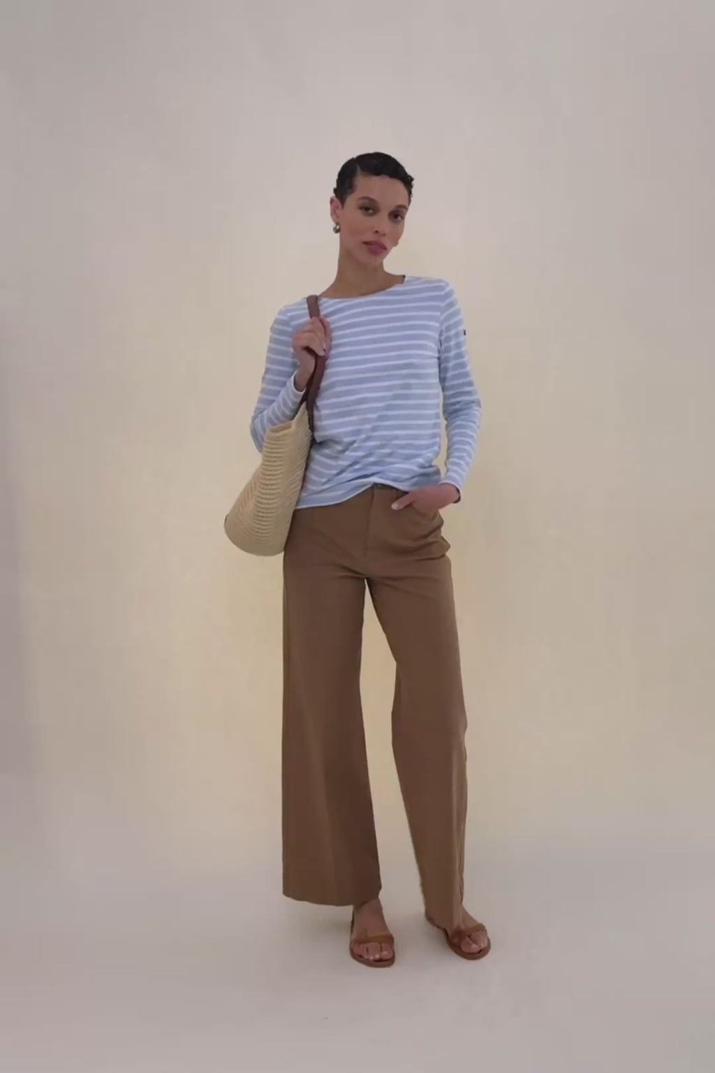 woman in sky blue shirt with beige pants.