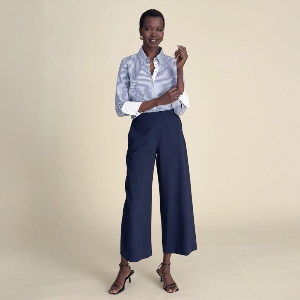 woman in blue striped button down with navy blue pants.
