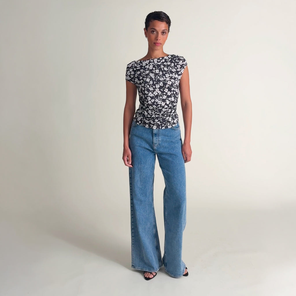Woman wearing the margaret top in happy floral and jeans