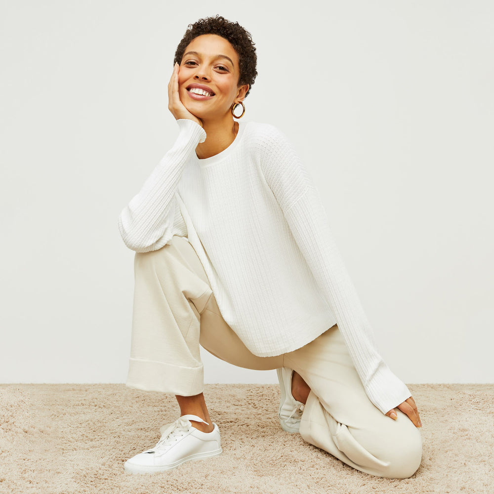 Front image of a woman standing wearing the tyler sweatshirt in ivory