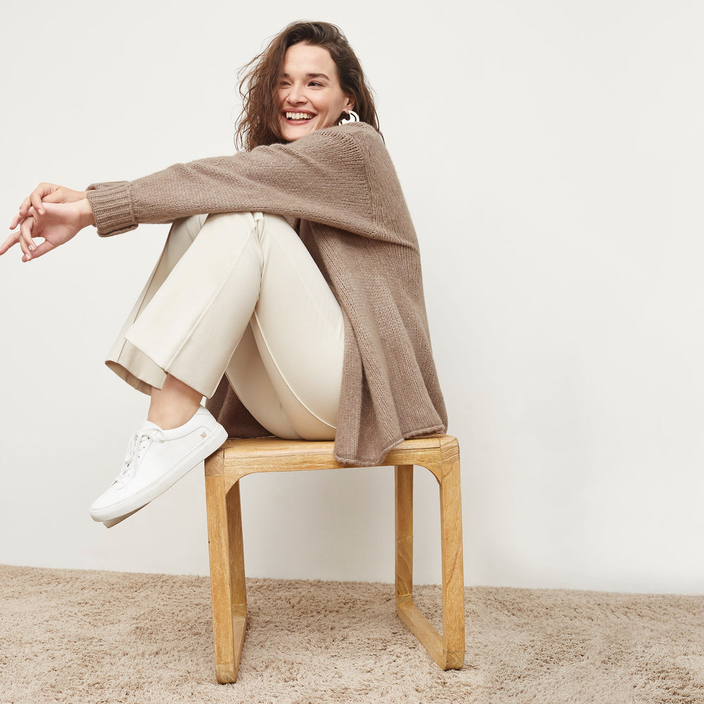 Side image of a woman standing wearing the Frederick Cardigan in Dark Taupe