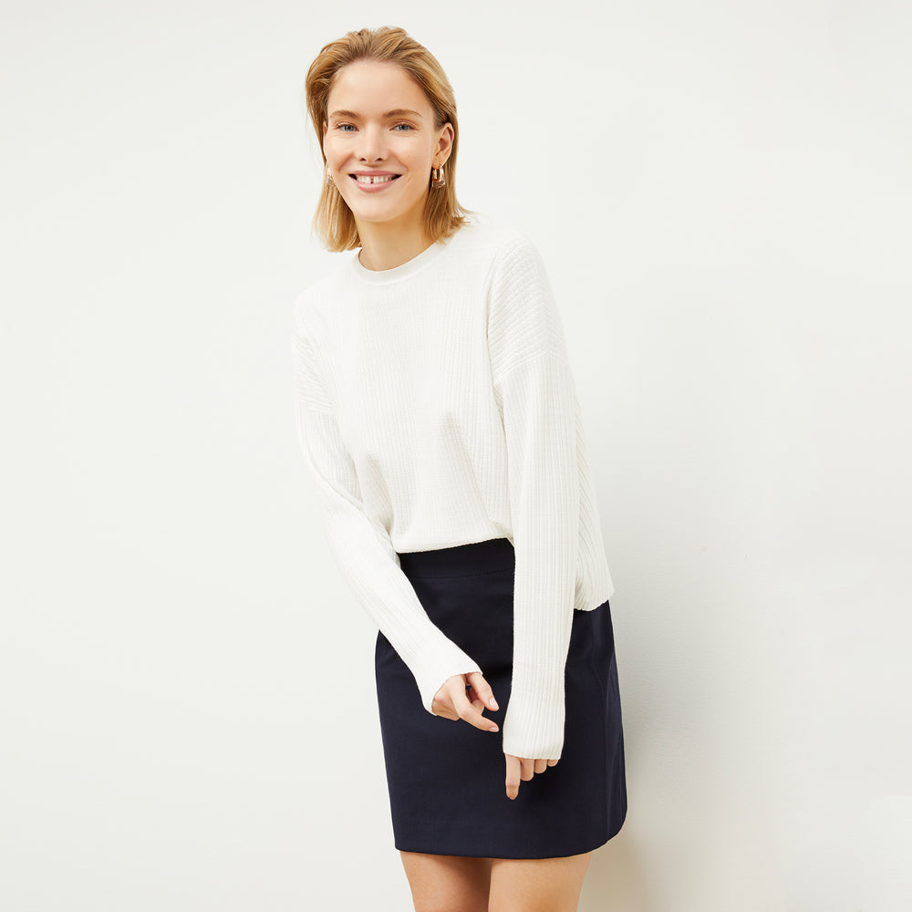 Front image of a woman standing wearing the tyler sweatshirt in ivory