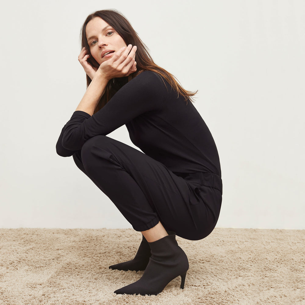 Side image of a woman standing wearing the Delaney Jogger—OrigamiTech in Black