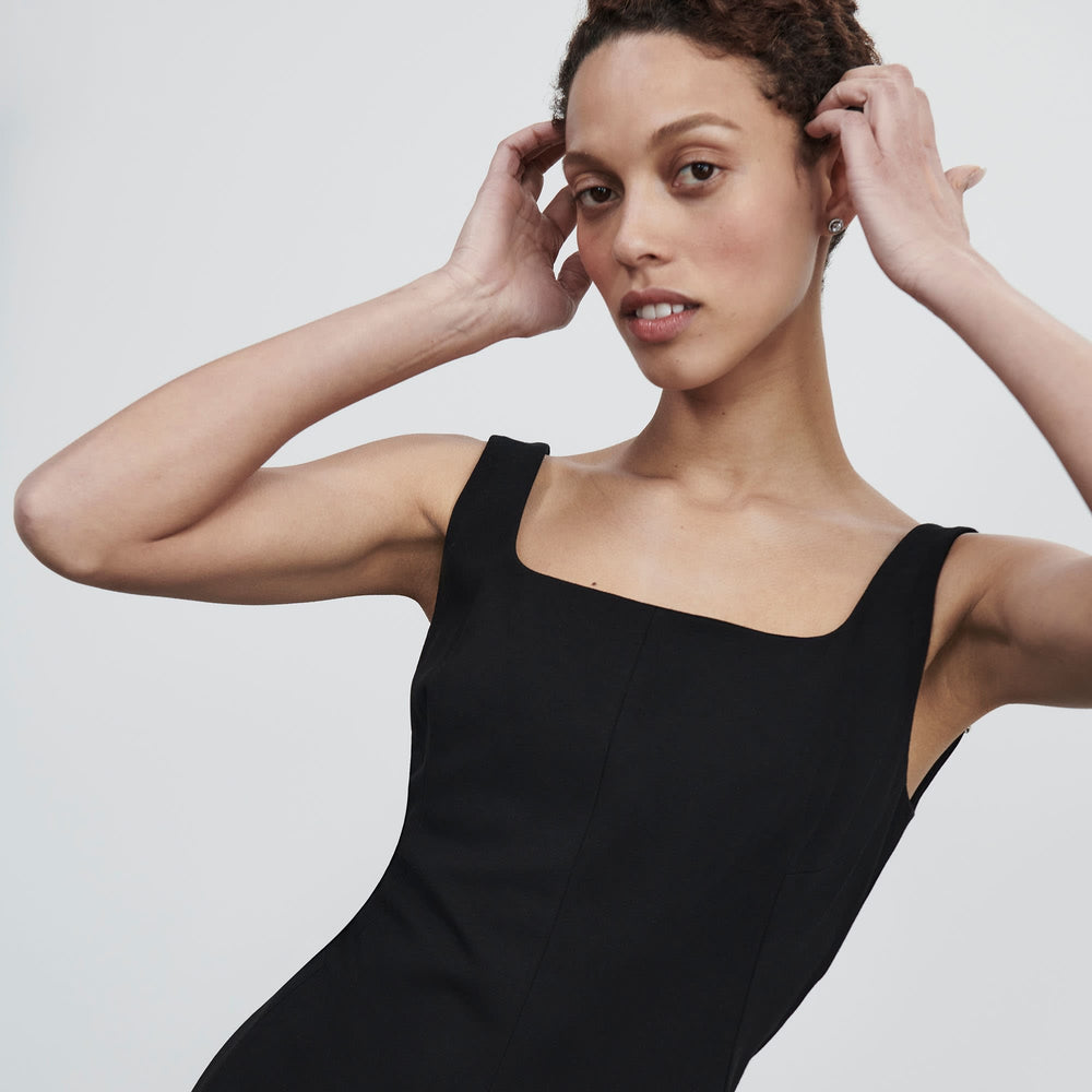Front image of a woman standing wearing the james dress in black